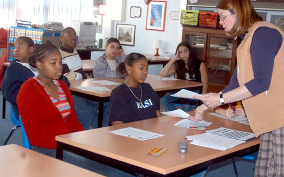 Students in the front row from right, Shayla Hall, 14, and Kasmira Watkins, 13, both eighth-grade students at the Darmstadt, Germany, Middle School, receive post-assessment tests on Internet safety from Heidi Tobin, an educational technologist, after watching a videotape depicting a child predator posting as a child in a chat room.