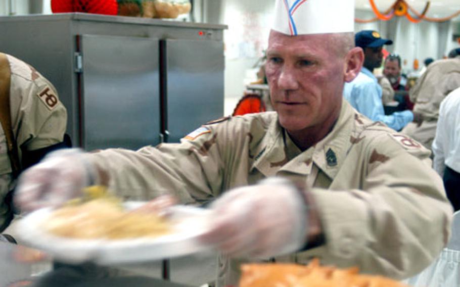 Command Sgt. Maj. Ed Whittington of the 172nd Corps Support Group serves up turkey dinner Thursday at Logistics Support Area Anaconda, Iraq.