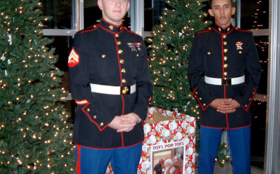 Marine Cpl. Daniel Belew and Pvt. Jeremy Martinez, both assigned to Marine Air Control Squadron 4, Futenma Marine Corps Air Base, Okinawa, stand a volunteer two-hour watch for Toys for Tots at the Camp Foster Exchange Wednesday night.