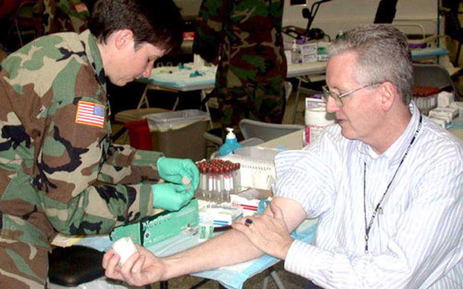 Ken Chapman, a defense analyst for the Air Force who is participating in the flu vaccine study, has blood drawn Tuesday at the Pentagon by Pfc. Denise Leonard, of Passadumkeag, Maine. Leonard is a lab technician at Walter Reed Army Institute of Research in Washington, D.C.