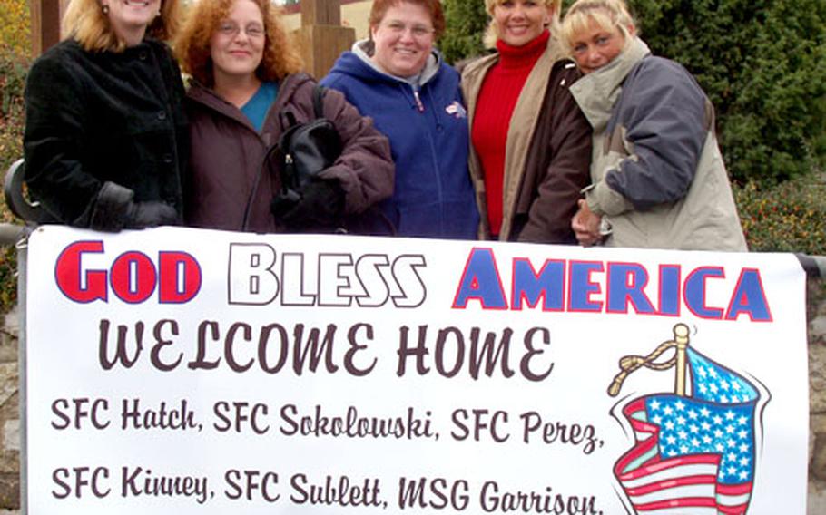From left, Alice Adler, Nicki Moser, Julie Hatch, Kim Sublett and Rhonda Garrison hold a sign Nov. 9 at Hohenfels, Germany, as they wait for their husbands to return from Iraq.