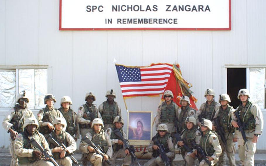 Soldiers from Battery C, 1st Battalion, 7th Field Artillery gather around a photo of their platoon-mate, Spc. Nicholas Zangara, at the dedication of the MWR facility at Camp Summerall in his memory. Zangara was killed July 24.