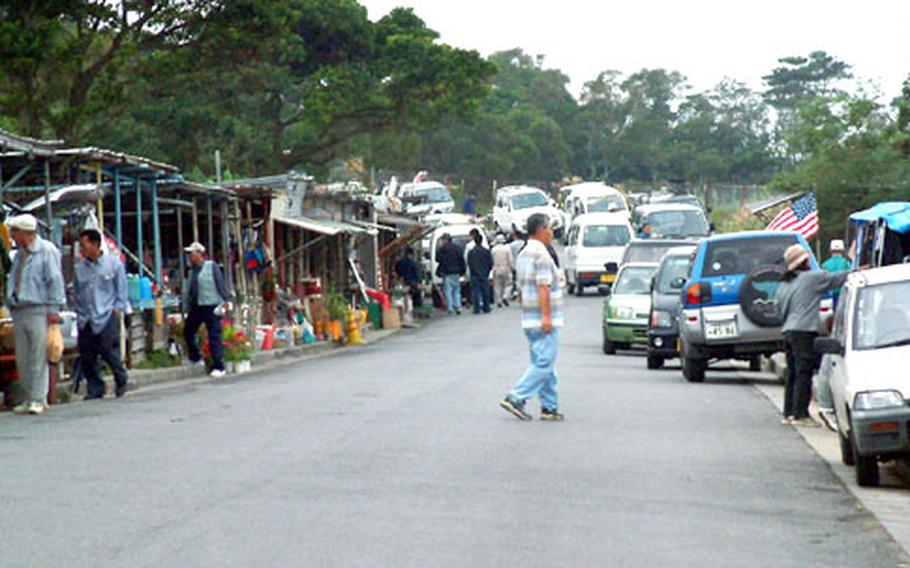 This flea market, on a public access road that cuts through the Kadena Ammunition Storage Area, has operated illegally since the early 1990s. Okinawa City plans to erect a fence to deny the merchants space for their stalls.