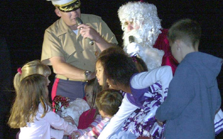 Col. James Kessler asks Santa and his helpers to flip the switch to light the base Christmas tree after the parade. With the help of the children, Santa completed the task.
