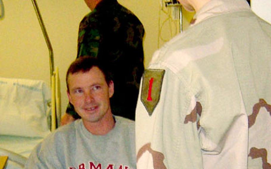 Capt. Mellanie Merrit, 601st Aviation Support Battalion rear detachment commander, speaks with Sgt. William Rigby, 1st Squadron, 4th Armored Cavalry Regiment, on Nov. 24 at Würzburg Hospital’s Victory Ward. Movies and snacks were delivered to injured 1st Infantry Division soldiers at the hospital as part of the Operation: Take a Soldier to the Movies program.