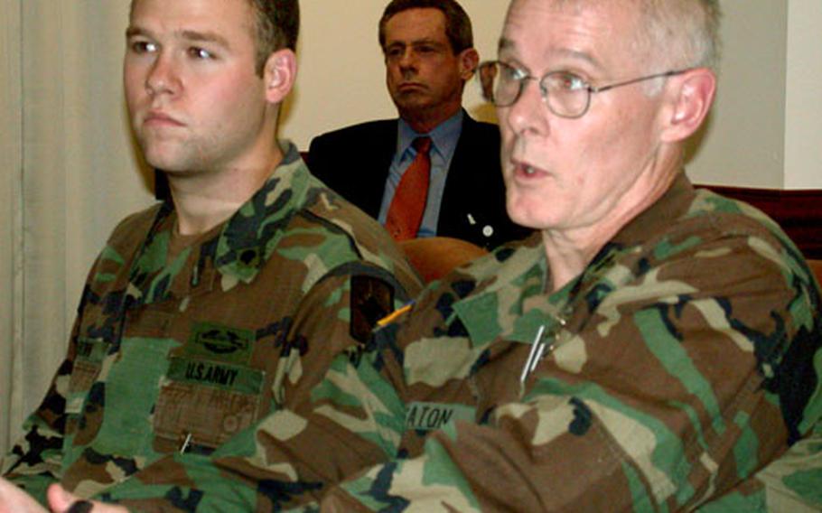 Spc. Logan Brown, a 21-year-old from Almeda, Ark., left, listens as Col. Michael Deaton, a family practice physician for the Army's Office of the Surgeon General, discusses a new Community-Based Health Care Initiative in which Brown participates.