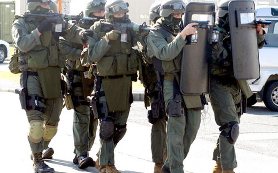 During the Active Shield exercise at Iwakuni Marine Corps Air Station, Japan, on Thursday, the station’s Special Reaction Team and Japanese Ground Self-Defense Force Rangers respond to a simulated hostage situation.