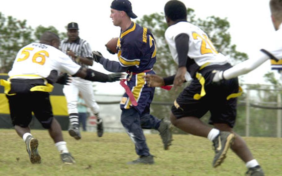 Navy cornerback Mark Bettencourt tries to avoid Army players after making his third interception of the Army-Navy game Saturday on Torii Station, Okinawa.