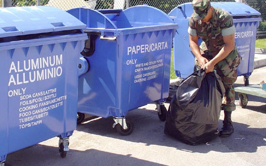 Petty Officer 2nd Class James Blue opens a bag full of scrap paper before dumping it in one of Naval Support Activity Naples's new recycling dumpsters. The base recently started a recycling program for paper, aluminum cans, cardboard and wood.