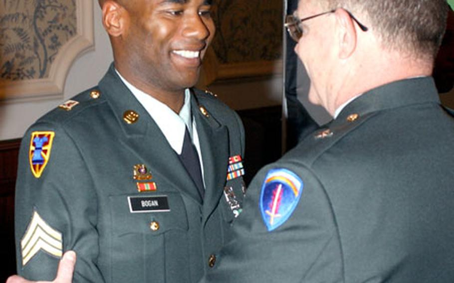 Sgt. Nicholas Bogan, 68th Transportation Company, 21st Theater Support Command, shakes hands with Brig. Gen. Larry C. Newman, Deputy Chief of Staff, Logistics, U.S. Army Europe. Bogan is the 2004 IMA-E and USAREUR Food Service NCO of the Year.