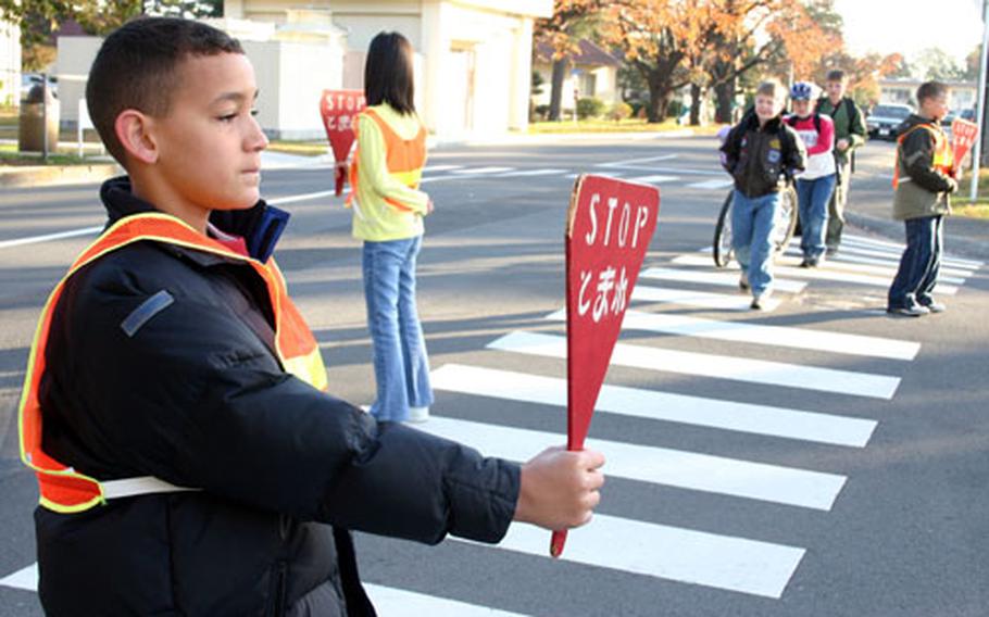Ten-year-old Andrew Vargas, a fifth-grader at Atsugi Naval Air Facility, Japan's Shirley Lanham Elementary School, keeps a watchful eye on traffic as students head to school.
