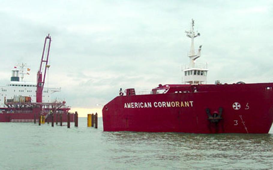The MV American Cormorant sits partially submerged near Southampton, England, last month as workers prepare to load floating Army equipment before the ship’s transit to the Middle East.