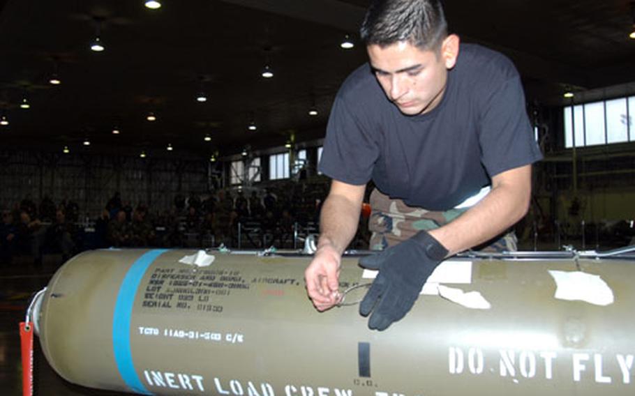 Senior Airman Juan Reyes, a weapons load crew member at Misawa Air Base, Japan, checks a cluster bomb unit during the 35th Maintenance Group's load crew competition Tuesday in Hangar 911.