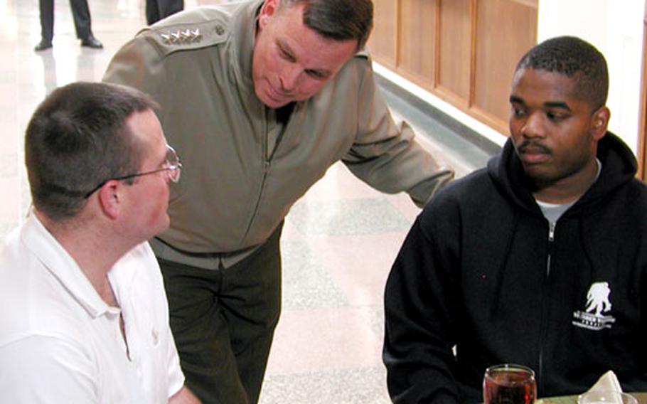 General William L. "Spider" Nyland, center, assistant commandant of the U.S. Marine Corps, talks with Army Reserve Sgt. Paul Shelmerdine, left, of Warren, Maine, and Spc. Arthur McLin of Tuscaloosa, Ala., before Thursday's dinner at the Pentagon. Shelmerdine and McLin were injured by improvised explosive devices while serving in Iraq.