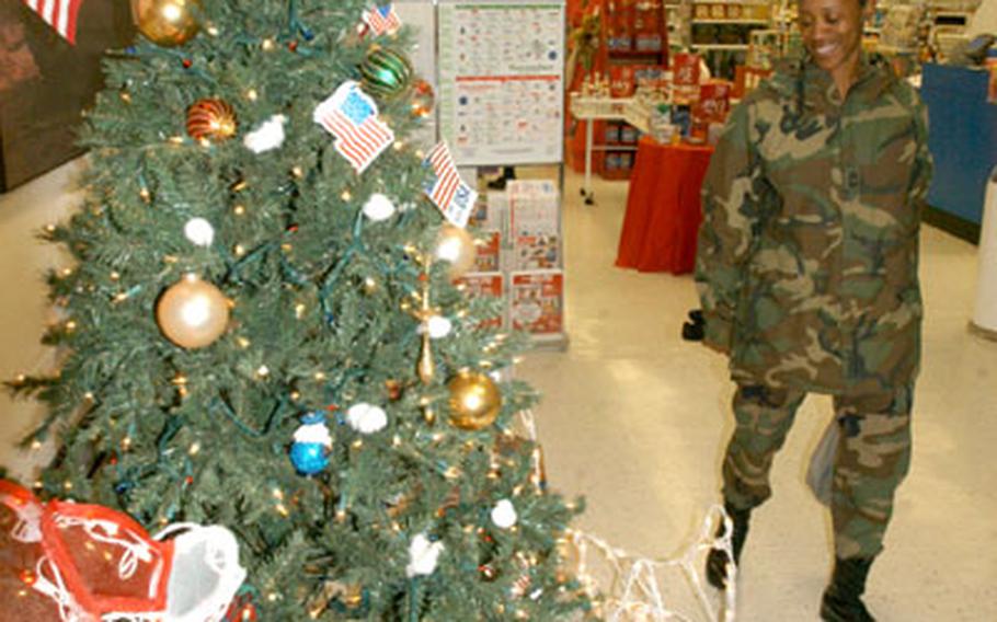 Master Sgt. Arlita Crawford of Huntsville, Texas, serving in South Korea with Headquarters and Headquarters Company, 2nd Infantry Division, checks out the patriotic Christmas tree at the Camp Red Cloud, South Korea, post exchange Wednesday.