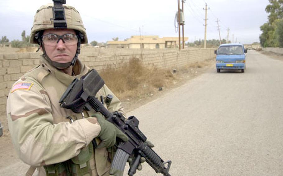 Staff Sgt. Robert Burns of the 2nd Battalion, 156th Infantry Regiment keeps watch during a raid on a farm compound Thursday outside of Baghdad. Intelligence reports said the compound was being used to manufacture roadside bombs, but a search of the area turned up nothing.