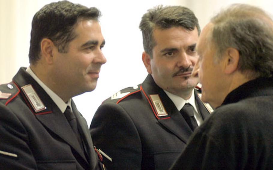 Italian Carabinieri members Antonio Altavilla, left, and Cosimo Visconti, center, visit with staff members at the Landstuhl Regional Medical Center in Germany on Thursday, a little more than a year after the soldiers were admitted to the hospital with critical injuries.