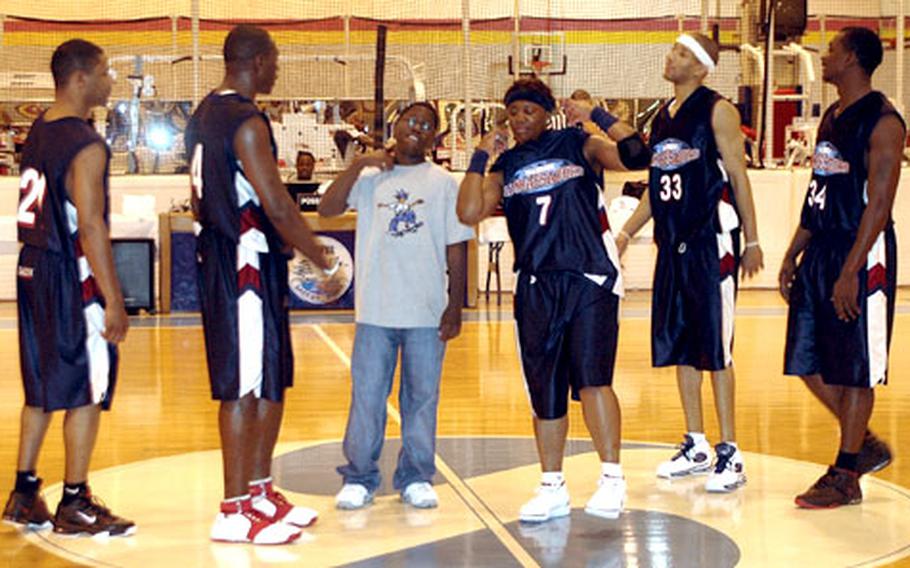 After winning a race against other kids attending the game, J.J. Sawyer, center, became the object of attention for the clowning Harlem Ambassadors basketball team at Sasebo Naval Base’s Fleet Gym. The Ambassadors, led by Ladè Majic (7), who tried to teach him to “walk cool” Saturday night.