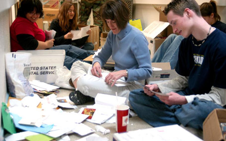 Volunteers pore through letters sent to troops at Landstuhl Regional Medical Center in Germany. The group helped chaplains at the hospital make up hundreds of holiday gift packets for patients and wounded soldiers. The volunteers, are, from left, Ariana Jeske, Carolyn Nichols, Amy Nichols, Brad Hedden and Stephanie Nichols (partially hidden in background).
