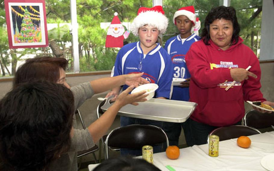 Diplomats soccer player Sydnie Bligh helps serve lunch Thursday. Nearly 50 people from the group — players and family members — attended the luncheon to help spread Christmas cheer.