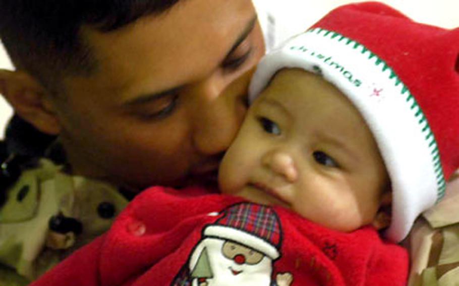 Spc. Jonathan Lucas of the 557th Medical Company (Ground Ambulance) kisses his 4-month-old daughter, Malia, after returning to Wiesbaden Army Airfield, Germany, from Iraq. Friday's reunion marked only the second time Lucas has seen his baby girl.