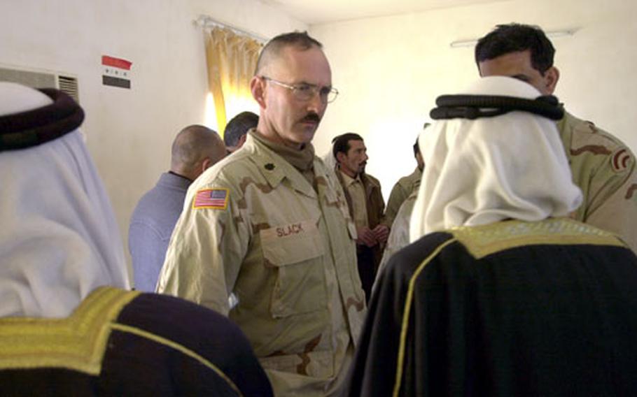 Lt. Col. Geoffrey Slack, 1st Battalion, 69th Infantry Regiment commander, talks with two local sheiks during a regional council meeting in Taji, Iraq. Local leaders say security is still the most important issue to be resolved.