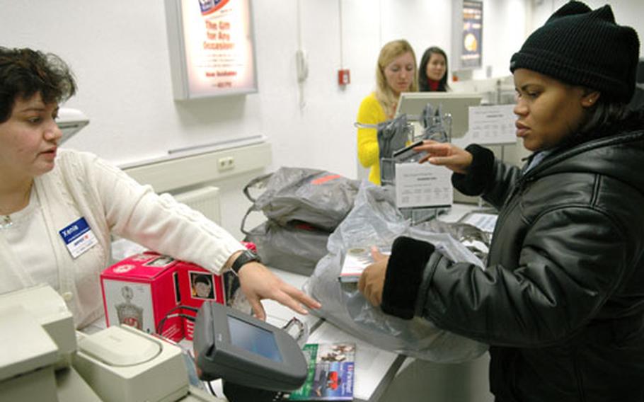 Xenia Valdez, left, assists Sgt. 1st Class Ruby Alexander with Christmas gifts she was returning at the Hainerberg Main Exchange in Wiesbaden, Germany, on Tuesday.