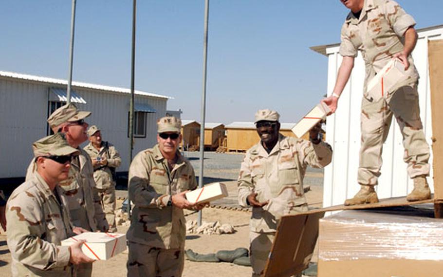 Sailors and Marines at Camp Morreel, Kuwait, receive Christmas gifts donated by the Morale, Welfare and Recreation Department’s stateside sponsorship drive.