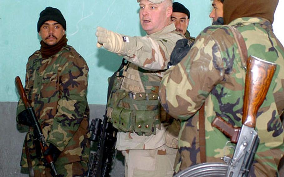 Staff Sgt. Greg Huffman gives directions to 2nd Brigade, Afghan National Army Centeral Corps soldiers on what to do once their team has breached a doorway.
