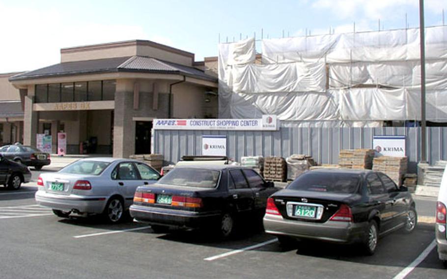 Plastic sheeting and scaffolding mark the site of a new post office under construction at Osan Air Base. The post office will be part of the recently opened Osan Shopping Mall, seen at left, the U.S. military's largest shopping center in South Korea.