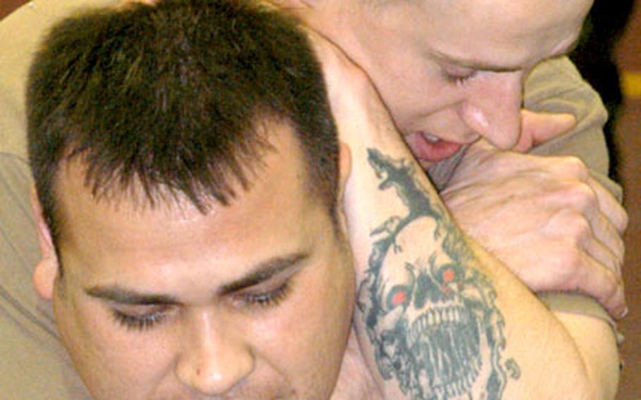Clifford Hartley has Larry Grijalva in a headlock as they learn a jujitsu move during training in Babenhausen, Germany, on Wednesday. Hartley and Grijalva are both staff sergeants with the 27th Field Artillery Regiment.