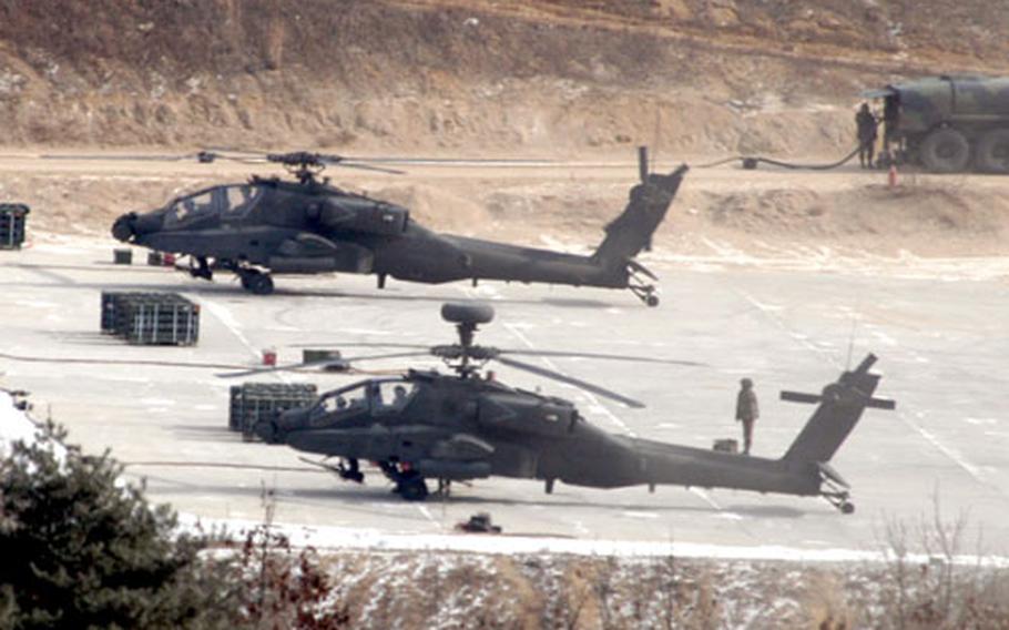 Apache helicopters from 1st Battalion, 2nd Aviation Regiment refuel and collect ammunition before practicing diving fire at Rodriguez Range.