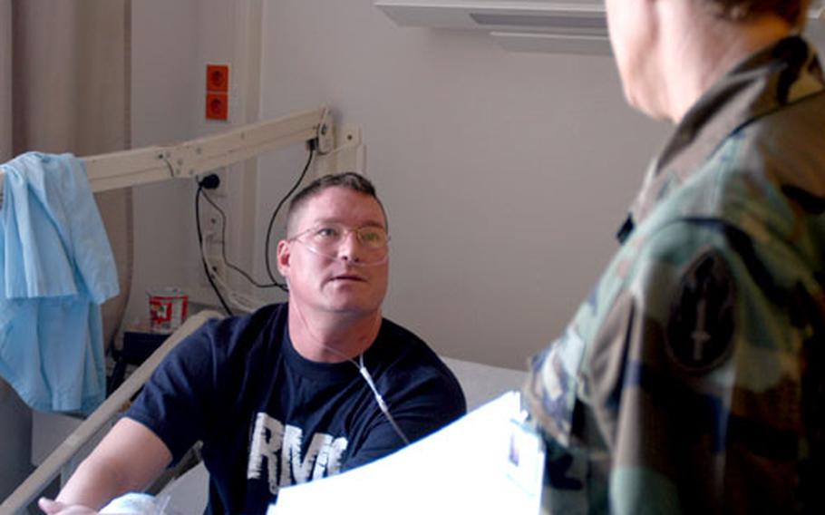 Col. Joanne Slyter, right, a dietician with the 328th Combat Support Hospital reserve unit, checks on Staff Sgt. Dominic Laufenberg, 31, of the 31st Combat Company based in Ramstein, Germany, at Landstuhl Regional Medical Center Friday morning.