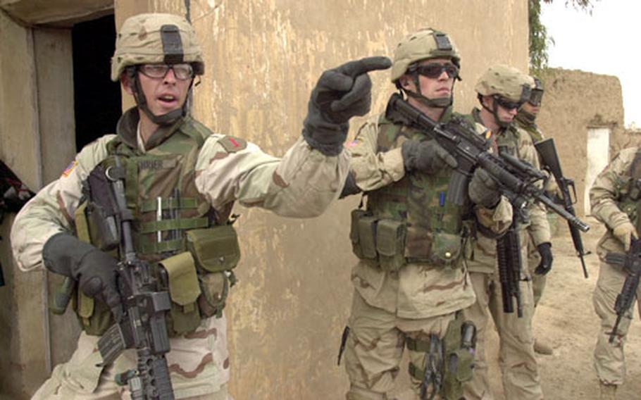 Iraqi elections may be over, but little has changed for 1st Infantry Division troops operating in central Iraq. Staff Sgt. Patrick Shrier from Charlie Troop, 1st Squadron, 4th Cavalry Regiment gets ready to search houses in a tiny village north of Tikrit. Acting on a tip, the unit arrested an arms dealer nearby in January, but found nothing this week on a follow-up search.