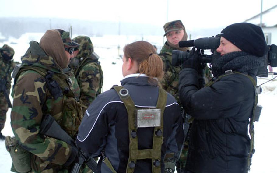 Global News Network reporters Spc. Tasha Woodson, left, and Spc. Allaina Parton of the 7th Army Training Command&#39;s Vipers team, grill a soldier at the Hohenfels Combat Maneuver Training Center last week, where members of the 40th Infantry Division were training for an upcoming mission in Kosovo.