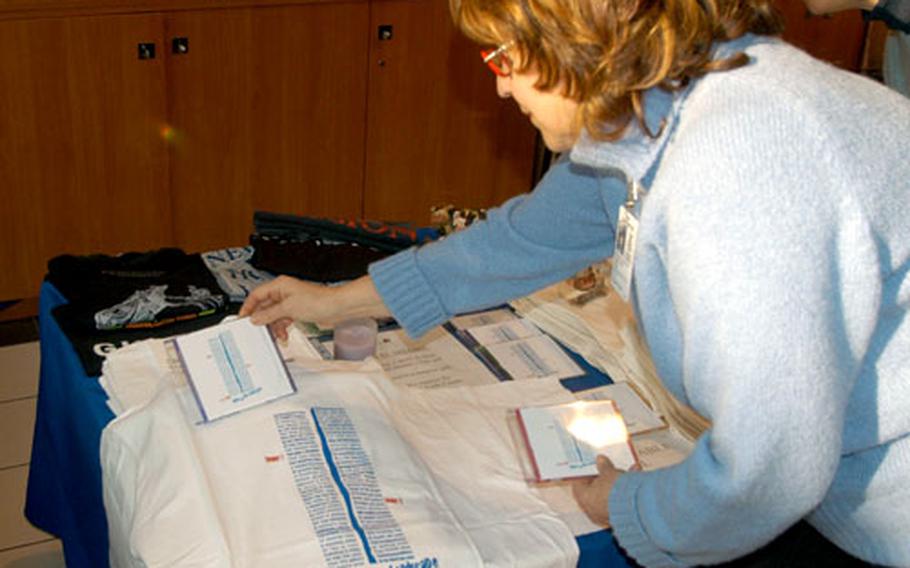 Myrna Goldstein adjusts one of the T-shirts, with her poem insipred by 9/11 attacks, that she and partner Gerardina Zeccola are currently selling at the exchange/commissary complex at Aviano Air Base, Italy.