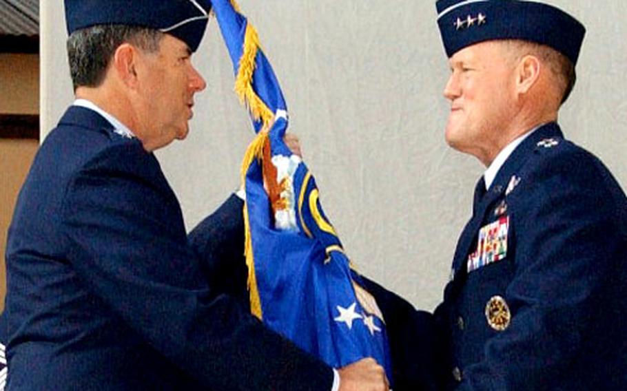 Gen. Paul Hester, left, Pacific Air Forces commander, passes command of the 5th Air Force to Lt. Gen. Bruce A. Wright during a change-of-command ceremony Thursday at Yokota Air Base, Japan.