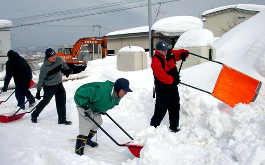 Sailors from the Yokosuka, Japan-based USS John S. McCain help dig out a school for the mentally challenged Tuesday in the city of Otaru on Japan's northern island of Hokkaido. The McCain completed a scheduled port visit to the city this week.