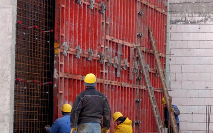 Builders at the Grafenwöhr, Germany, training area work Tuesday on a wall of what will become the base dining facility. The renovation is part of the expansive Effecient Basing Grafenwöhr project that will double the size of the installation over the next several years.