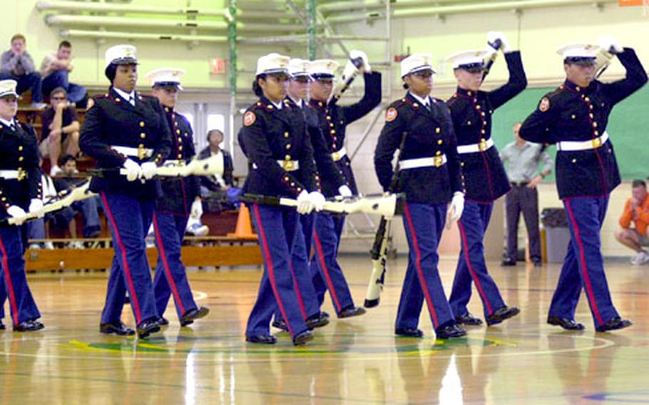 Members of Kubasaki High School's Marine Corps Junior Reserve Officers Training Corps drill team perform an eight-minute silent drill routine for their schoolmates Monday.