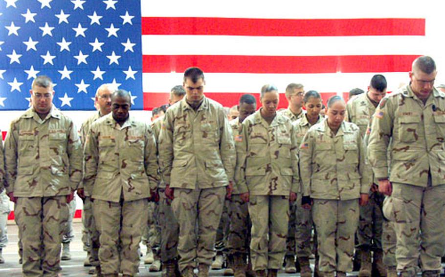 As a chaplain gives an invocation, soldiers from the 1st Infantry Division's headquarters staff bow their heads in prayer at a brief welcome-home ceremony just after midnight Thursday in Würzburg, Germany.