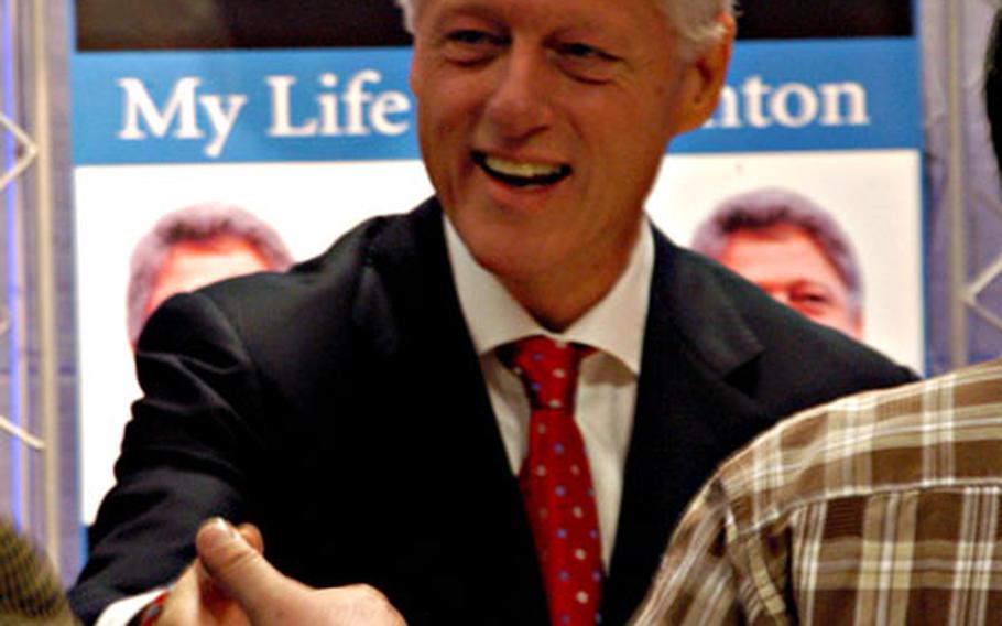 Former President Bill Clinton greets a Korean man during a book signing Friday afternoon at the Kyobo Book Centre in Seoul.