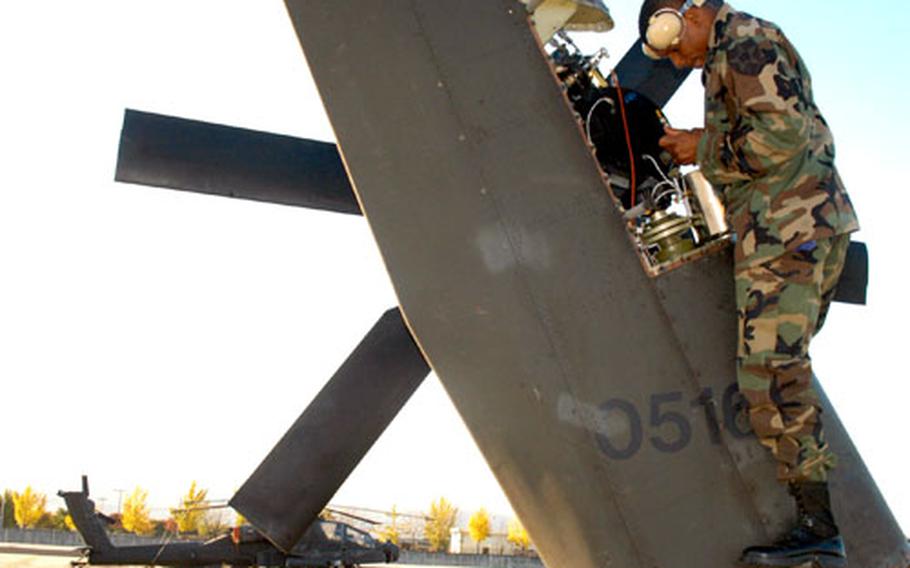 Staff Sgt. Darius Lazare, 34, of St. Thomas, Virgin Islands, services the tail rotor on an Apache helicopter last fall at Camp Page, South Korea. Last week, citizens from the South Korean city of Chunchon held a ceremony to say goodbye to U.S. soldiers serving at Camp Page.