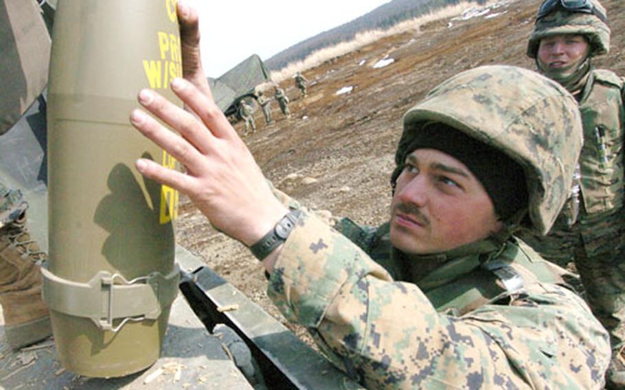 Pfc. Tony Defeo grabs a 155 mm shell for a Howitzer during live-fire training at Camp Fuji, Japan, on Wednesday. He is with the India Battery of the 3rd Battalion, 12th Marine Regiment, temporarily based on Okinawa, that deployed to Camp Fuji for training.