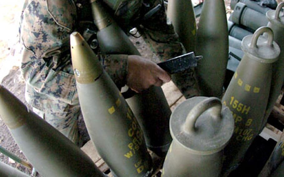 Pvt. James Killen attaches fuses to 155 mm Howitzer shells.