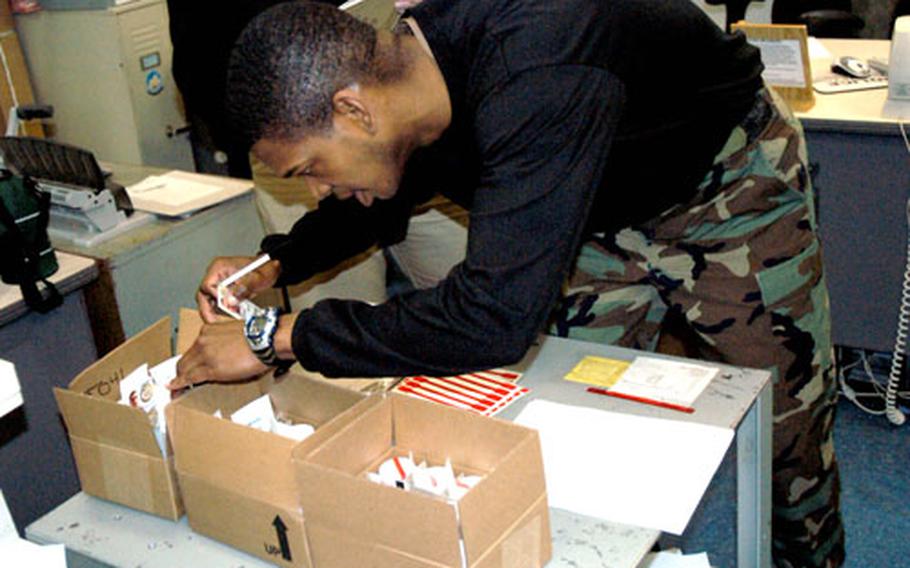 Petty Officer 1st Class Eric Patrick Butts, master-at-arms and command investigator on the USS Kitty Hawk, looks over containers that will be used to collect urine under the stringent 7th Fleet urinalysis drug testing program. From the moment sailors are randomly selected for testing, the process follows a careful procedure to prevent tampering until Butts receives and seals each sample.