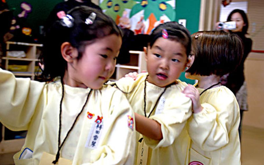 Julia Sanders, center, and Madaline Stephens, play a game during a recent Parent's Day at Daiichi Yochien, a private, Japanese kindergarten in Misawa city in northern Japan. Julia and Madaline are among a handful of American students attending the school. Their parents, who either live or work at Misawa Air Base, chose an off-base preschool program for the language and cultural experience.