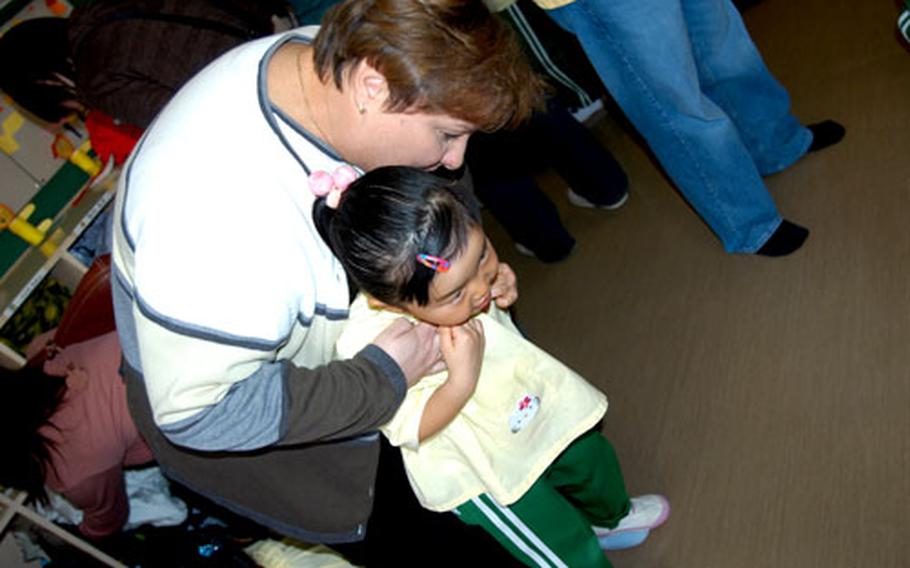 Heather Sanders, a Department of Defense Dependents School teacher at Misawa Air Base, Japan, hugs her daughter, Julia, 5, during a recent Parent's Day at private kindergarten Daiichi Yochien in Misawa city. Sanders chose Daiichi over on-base preschool for the language and cultural exposure.