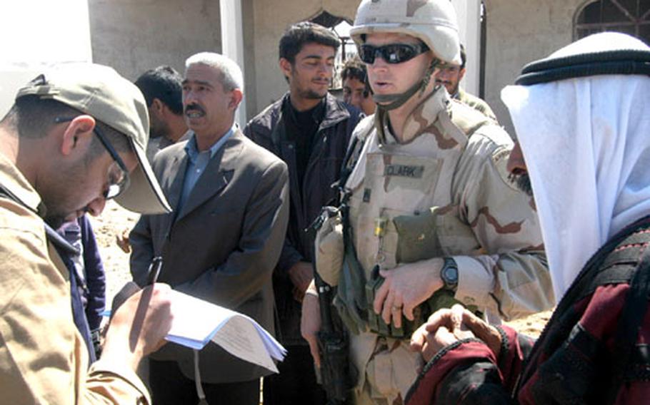 Staff Sgt. Richard Clark of Victorville, Calif., and the 426th Civil Affairs Battalion goes over paperwork with an interpreter, left, and Iraqis during an inspection March 26 in Laq Laq, Iraq. Civil affairs personnel teach local Iraqi governments to handle problems from repairing buildings to fixing water mains.