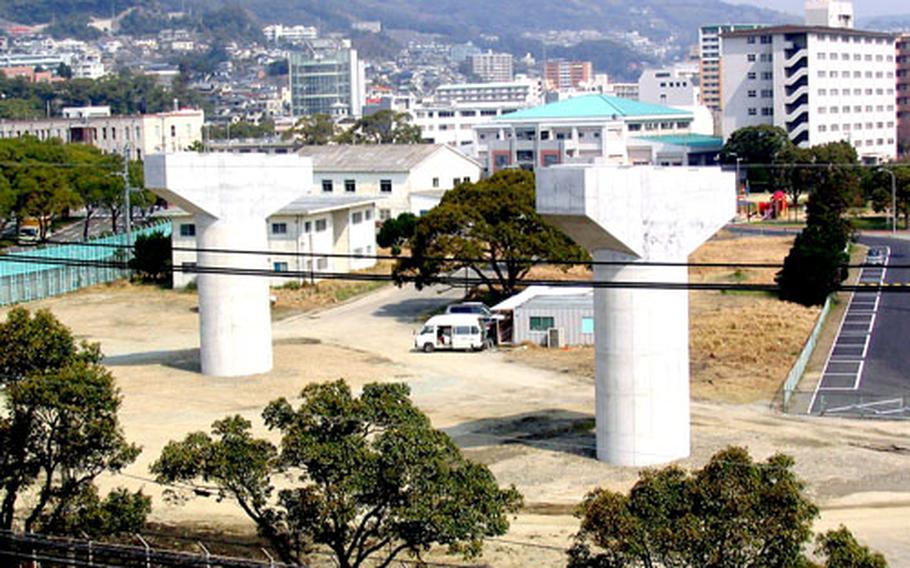 Shown from the top parking deck of Sasebo Naval Base’s Public Works Building and Safety Department on Friday, concrete expressway supports are in place across the highway along Nimitz Park. The supports represent what’s to be an extention of the Nishi-Kyushu Expressway, eventually passing through a portion of the main base housing and forcing a number of U.S. personnel to be displaced.